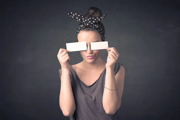 Söt flicka som håller blankt kopiera utrymme papper vid hennes ögon — Stockfoto