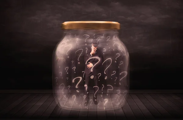 Businessman locked into a jar with question marks concept — Stock Photo, Image