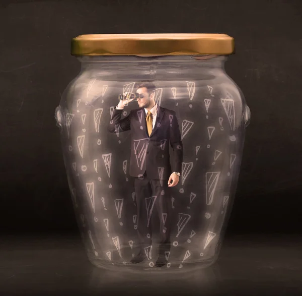 Business man trapped in jar with exclamation marks concept — Stock Photo, Image