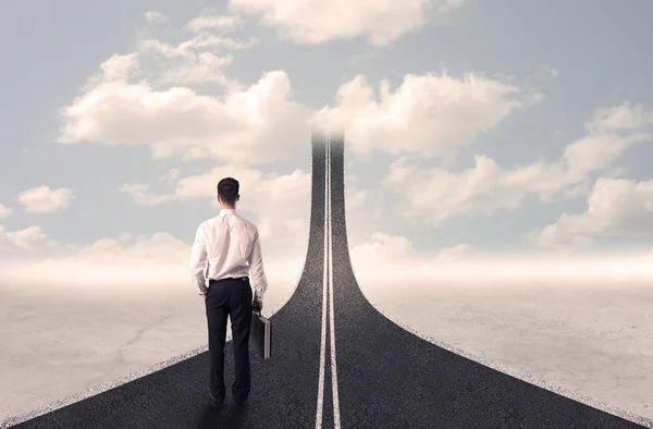 Businessman looking at 3d road that goes up in the sky — Stock Photo, Image