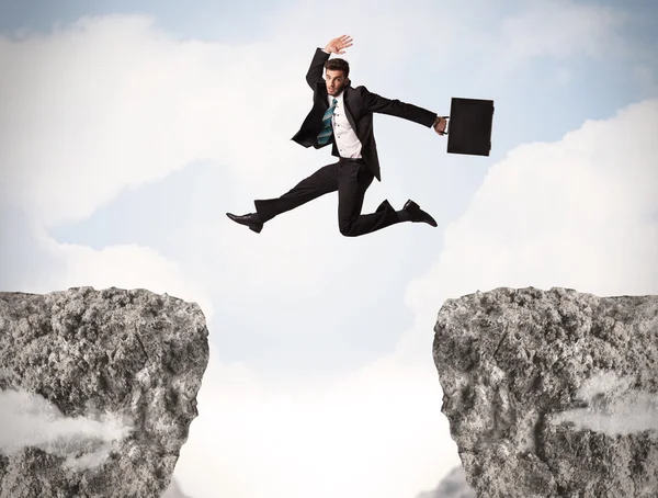 Funny business man jumping over rocks with gap Stock Picture