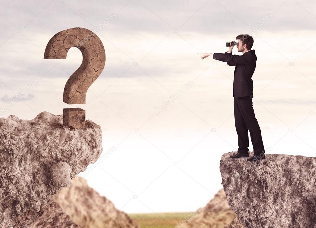 Businessman on rock mountain with a question mark