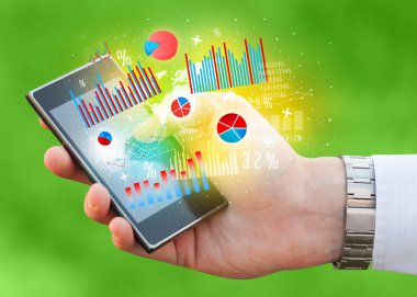 İşadamı elinde grafik sembollü akıllı telefon tutuyor.
