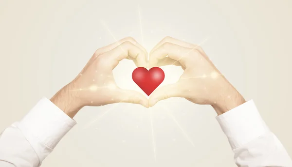 Hands creating a form with shining heart — Stock Photo, Image