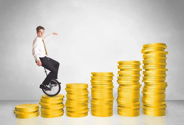 Business man riding monocycle up on coin graph — Stock Photo, Image