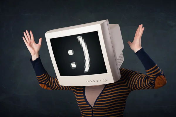 Grappig meisje met een monitor doos op haar hoofd en een smiley — Stockfoto