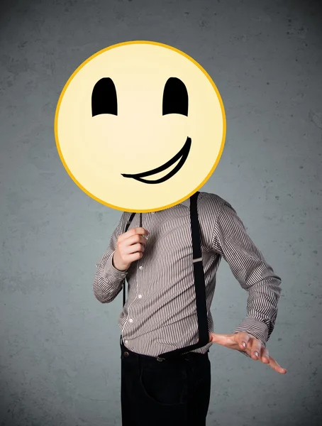 Empresário segurando um emoticon rosto sorridente — Fotografia de Stock