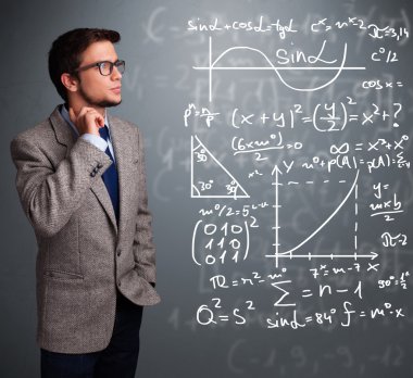 Karmaşık matematiksel işaretleri düşünen yakışıklı okul çocuğu.