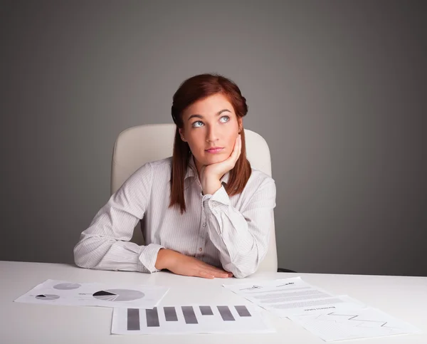 Zakenvrouw zit achter het bureau en doet papierwerk — Stockfoto