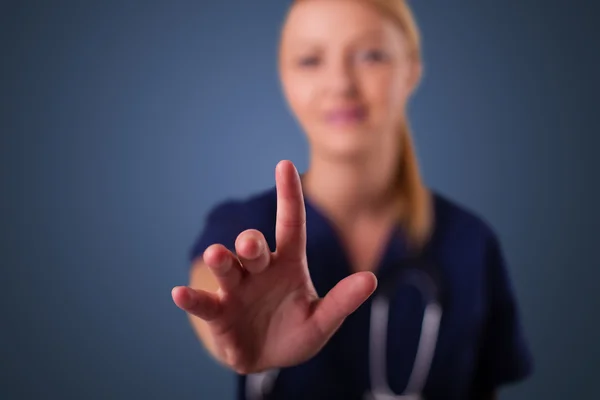 Jonge vrouwelijke arts gebaren met kopieerruimte — Stockfoto