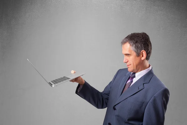 Красивий бізнесмен тримає сучасний ноутбук — стокове фото