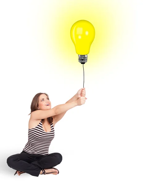 Mulher feliz segurando um balão lâmpada — Fotografia de Stock