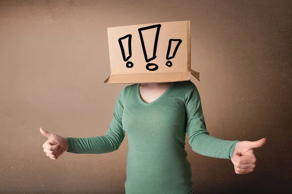 Jonge dame met een kartonnen doos op haar hoofd met excla gebaren — Stockfoto