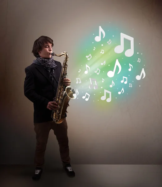 Young musician playing on saxophone while musical notes explodin — Stock Photo, Image