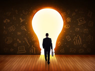 parlak ampul duvara bakarak iş adamı 