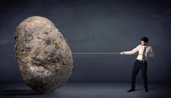 Businessman pulling huge rock with a rope — Stock Photo, Image