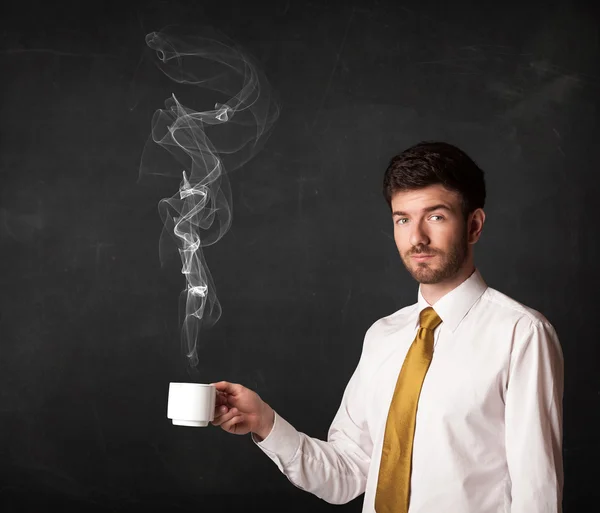 Businessman holding a white steamy cup — Stock Photo, Image