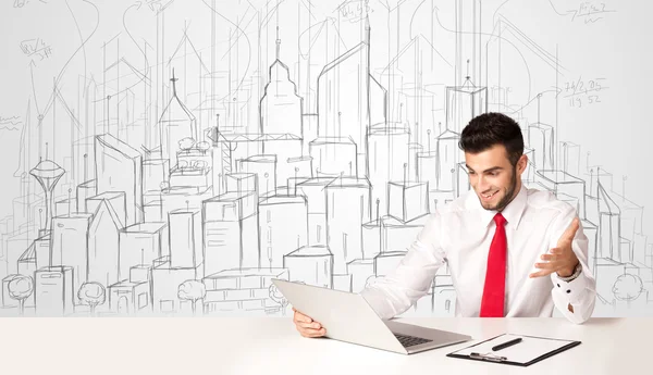 Zakenman zittend aan de witte tafel met handgetekende gebouwen — Stockfoto