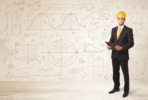 Handsome engineer calculating with hand drawn background — Stock Photo, Image