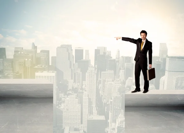 Businessman standing on the edge of rooftop — Stock Photo, Image