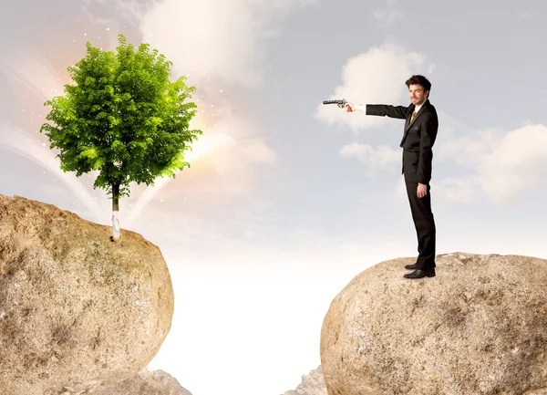 Businessman on rock mountain with a tree — Stock Photo, Image