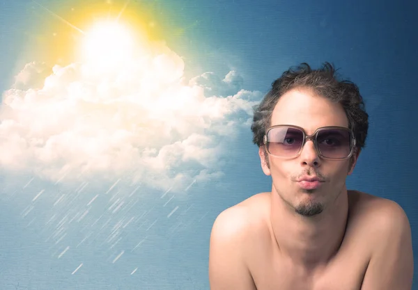 Молодой человек в солнечных очках смотрит на облака и солнце — стоковое фото