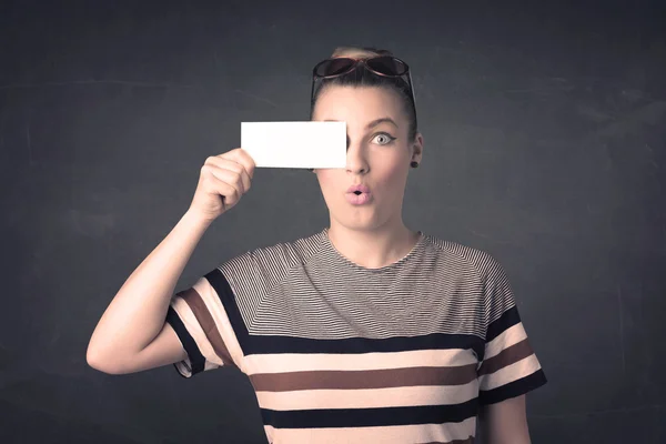 Söt flicka som håller blankt kopiera utrymme papper vid hennes ögon — Stockfoto