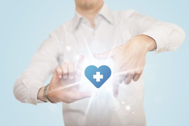 Eller mavi haçlı bir kalp yaratıyor.