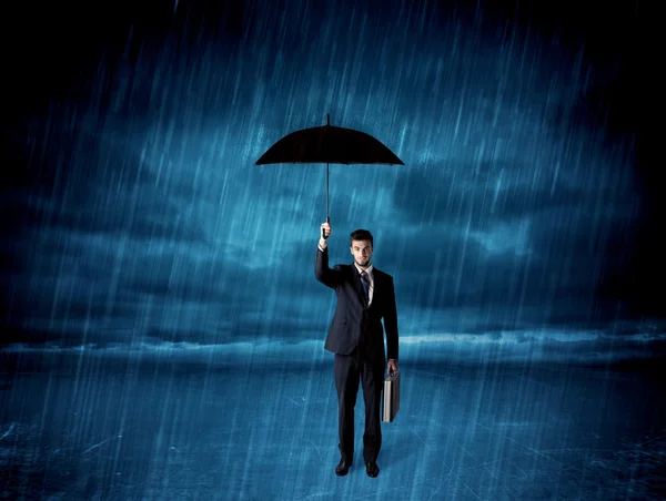 Επιχειρηματίας στέκεται στη βροχή με μια ομπρέλα — Φωτογραφία Αρχείου