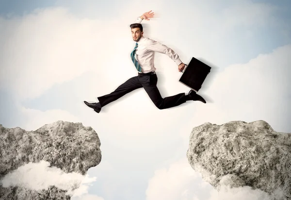 Homem de negócios feliz saltando sobre um penhasco — Fotografia de Stock