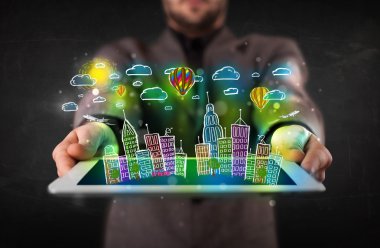Elle çizilmiş şehir manzaralı tablet gösteren genç kişi