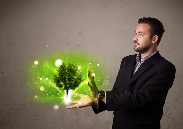 Gloeiende boom groeien in de hand van een zakenman — Stockfoto