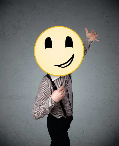 Empresario sosteniendo un emoticono sonriente —  Fotos de Stock