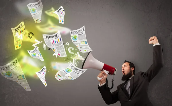 Guy yelling into loudspeaker and newspapers fly out — Stock Photo, Image