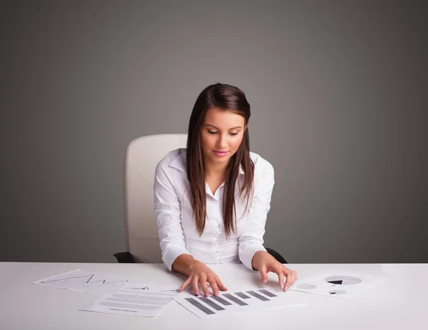 Mulher de negócios sentada na mesa e fazendo papelada — Fotografia de Stock