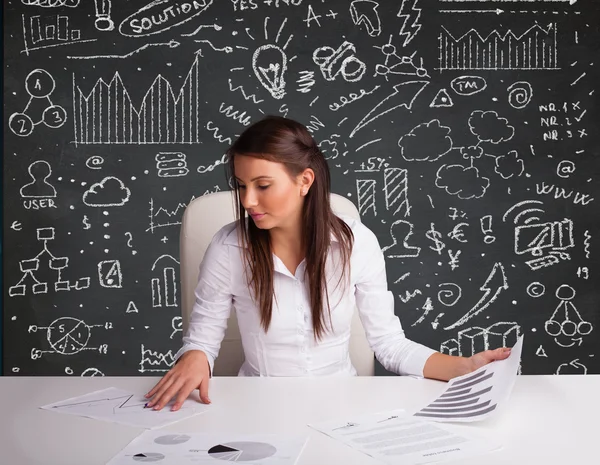 Zakenvrouw zit aan het bureau met zakelijke regeling en pictogrammen — Stockfoto