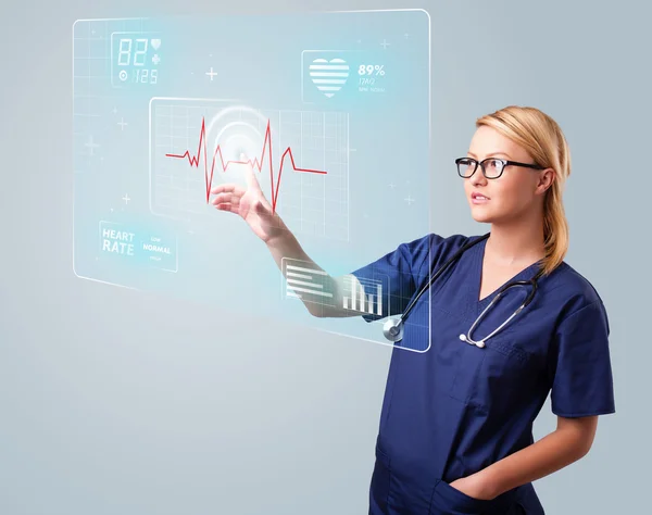 Young nurse pressing modern medical type of buttons — Stock Photo, Image