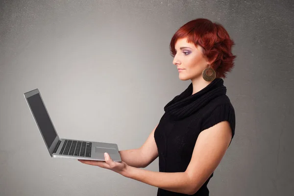 Νεαρή γυναίκα που κρατά σύγχρονο φορητό υπολογιστή — Φωτογραφία Αρχείου