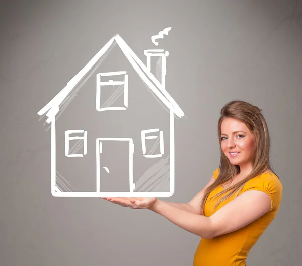 Young lady holding a huge drawn house — Stock Photo, Image