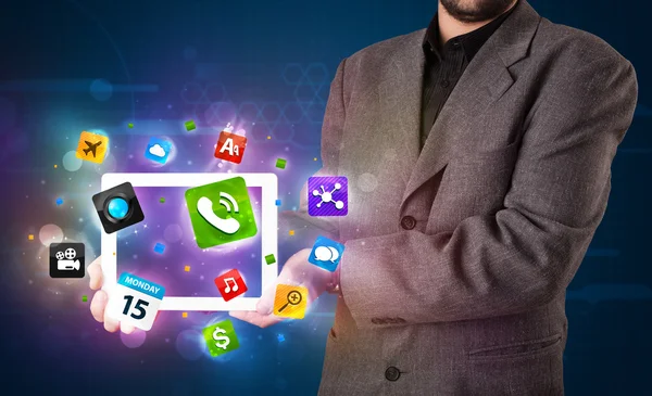 Üzletember kezében egy tabletta modern színes alkalmazások és ikonok — Stock Fotó