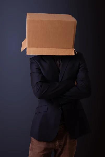 Young man gesturing with a cardboard box on his head — Stock Photo, Image