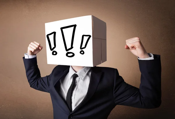 Businessman gesturing with a cardboard box on his head with excl — Stock Photo, Image