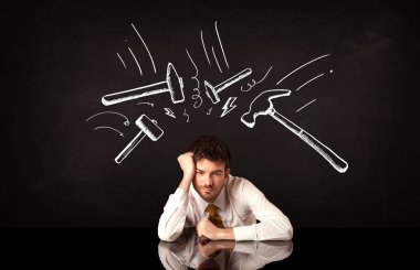 Depresyondaki işadamı çekiç izlerinin altında oturuyor