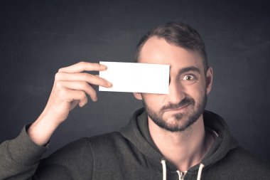 Yakışıklı bir adam elinde fotokopi kağıdı tutuyor.
