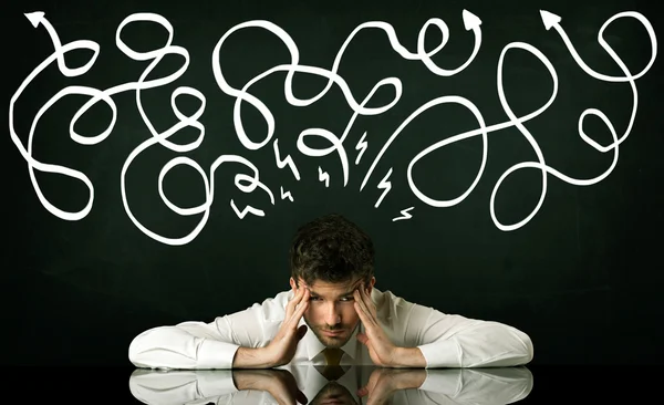 Depressed businessman sitting under drawn direction lines — Stock Photo, Image