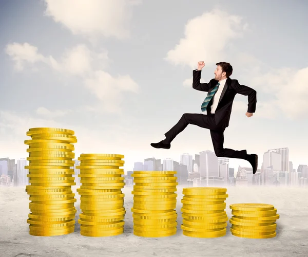 Homem de negócios bem sucedido pulando em dinheiro de moeda de ouro — Fotografia de Stock