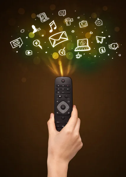 Hand with remote control and social media icons — Stock Photo, Image