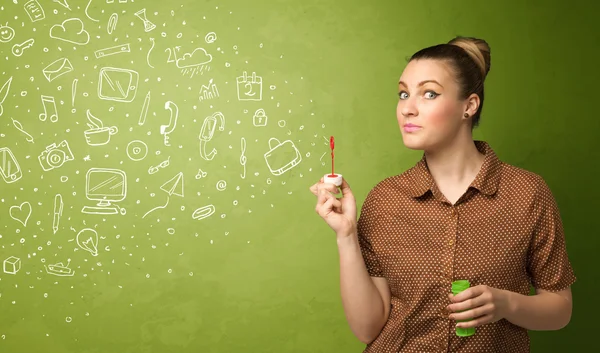 Cute girl blowing hand drawn media icons and symbols — Stock Photo, Image