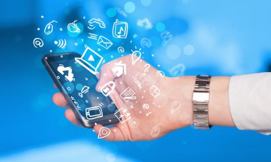 Medya simgeleri ve sembolleriyle el ele tutuşan akıllı telefon 
