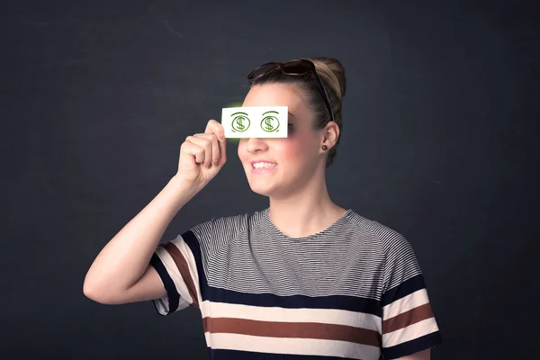 Молодая девушка держит бумагу с зеленым знаком доллара — стоковое фото